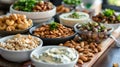 Assortment of nuts and dips in bowls on wooden cutting board Royalty Free Stock Photo