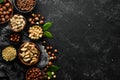 Assortment of nuts: pistachios, hazelnuts, pine nuts on a black stone background. free space for your text. Royalty Free Stock Photo