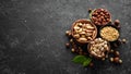 Assortment of nuts: pistachios, hazelnuts, pine nuts on a black stone background. free space for your text. Royalty Free Stock Photo