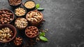 Assortment of nuts: pistachios, hazelnuts, pine nuts on a black stone background. free space for your text. Royalty Free Stock Photo