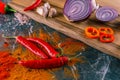 Assortment of peppers, garlic and onions on a stone countertop Royalty Free Stock Photo