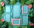 A collection of empty pink and blue picture frames arranged in a creative flat lay among vibrant tropical leaves. Royalty Free Stock Photo