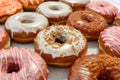 An assortment of pink-frosted donuts, some with colorful sprinkles and others with a light dusting of sugar, arranged on