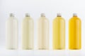 Assortment of plastic tall bottles with beverage of different pastel pale colors or cosmetic essential oil silver cap mockup.