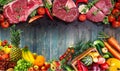 Assortment of raw meat on a wooden table with vegetables Royalty Free Stock Photo