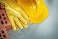 Assortment of red bricks hard hat safety gloves on concrete back Royalty Free Stock Photo