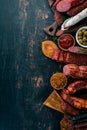 Assortment of salami and snacks. Sausage Fouet, sausages, salami, paperoni. On a black wooden background. Royalty Free Stock Photo