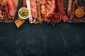 Assortment of salami and snacks. Sausage Fouet, sausages, salami, paperoni. On a black wooden background. Royalty Free Stock Photo