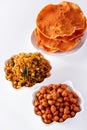 Assortment salty crunchy indian mix Nimco or Namkeen, spicy coated peanut and pappadam white bowl wooden background