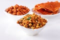 Assortment salty crunchy indian mix Nimco or Namkeen, spicy coated peanut and pappadam white bowl wooden background Royalty Free Stock Photo