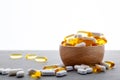 Assortment scattered pharmaceutical medicine tablets, pills, drugs in wooden bowl on gray background. White food dietary Royalty Free Stock Photo