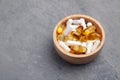 Assortment scattered pharmaceutical medicine tablets, pills, drugs in wooden bowl on gray background. White food dietary Royalty Free Stock Photo