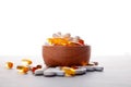 Assortment scattered pharmaceutical medicine vitamins, pills, drugs in wooden bowl on gray background. White food