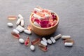 Assortment scattered pharmaceutical medicine vitamins, pills, drugs in wooden bowl on gray background. White food dietary Royalty Free Stock Photo