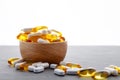 Assortment scattered pharmaceutical medicine vitamins, pills, drugs in wooden bowl on gray background. White food