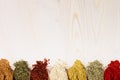 Assortment of scattered powder spices close-up on white wooden board with copy space.