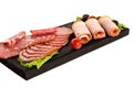 Assortment of sliced sausages with vegetables on a black kitchen board. Royalty Free Stock Photo