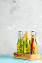 Assortment of sunflower, corn, olives oils with herbs and spices in different bottles on light concrete background Royalty Free Stock Photo