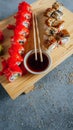 an assortment of sushi and japanese foods on a wooden platter