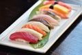 Assortment sushi on a white plate over the black table