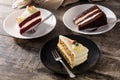 Assortment of sweet cake slices. Chocolate, carrot and velvet cake slices on wood