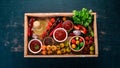 Assortment of tomato sauces in a wooden box. oes, spices, chili peppers, olive oil, parsley.