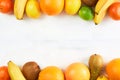 Assortment of tropical fruits orange, tangerine, banana, grapefruit, lemon, lime, kiwi on white background. Copy space.