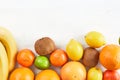 Assortment of tropical fruits orange, tangerine, banana, lemon, lime, kiwi on white background. Fresh fruit set