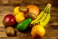 Assortment of tropical fruits on wooden table. Still life with bananas, mango, oranges, avocado, grapefruit and kiwi fruits Royalty Free Stock Photo