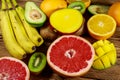 Assortment of tropical fruits on wooden table. Still life with bananas, mango, oranges, avocado, grapefruit and kiwi fruits Royalty Free Stock Photo