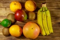 Assortment of tropical fruits on wooden table. Still life with bananas, mango, oranges, avocado, grapefruit and kiwi fruits Royalty Free Stock Photo