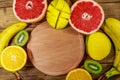 Assortment of tropical fruits on wooden table. Still life with bananas, mango, oranges, grapefruit and kiwi fruits Royalty Free Stock Photo