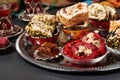 Assortment of Turkish sweets on a round metal tray on dark gray background. Closeup Royalty Free Stock Photo