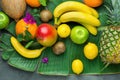 Assortment Variety of Tropical Seasonal Summer Fruits Pineapple Mango Oranges Lemons Kiwi Coconut Bananas on Large Palm Leaf