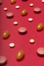 Assortment of various colourful pills red coloured background. Medication and prescription pills. Royalty Free Stock Photo