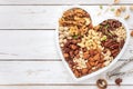 Assortment of various nuts in a heart shaped plate Royalty Free Stock Photo