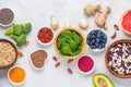 Assortment of various super foods for clean eating antioxidant detox diet on white background. Spinach, ginger, berries