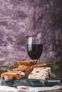 An assortment of various types of cheese with wine, and grapes, shot from above on a dark rustic background with a place Royalty Free Stock Photo