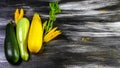 Assortment zucchini and zucchini flowers on a black wooden table. Top view. Copy space Royalty Free Stock Photo