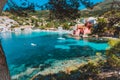 Assos village, Kefalonia, Greece. View on tourquise transparent water framed between green pine grove branches. Deep