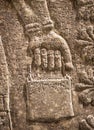 Assyrian wall relief of winged genius, detail with a hand