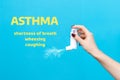 Asthma. A female`s hand presses the pump of the inhaler, spraying the medicine. Side view. Blue background with text