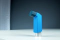 An asthma inhaler lies on a white table against a gray background, an asthmatic attack. The concept of treatment of bronchial Royalty Free Stock Photo