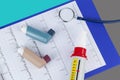 Asthma inhalers and a peak flow meter on a medical clipboard Royalty Free Stock Photo