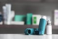 Asthma inhalers on table against blurred background.