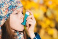 Asthma patient girl inhaling medication for treating shortness o