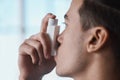 Asthma pump, breathe and man with healthcare, medicine and wellness spray for health. Breathing, inhaler and lung relief Royalty Free Stock Photo