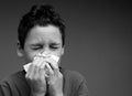 asthmatic breathing problems catching the flu child blowing nose after having a cold on grey background with people stock photo Royalty Free Stock Photo