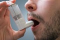 Asthmatic man suffers from asthma and is using inhaler Royalty Free Stock Photo