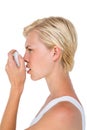 Asthmatic pretty blonde woman using inhaler